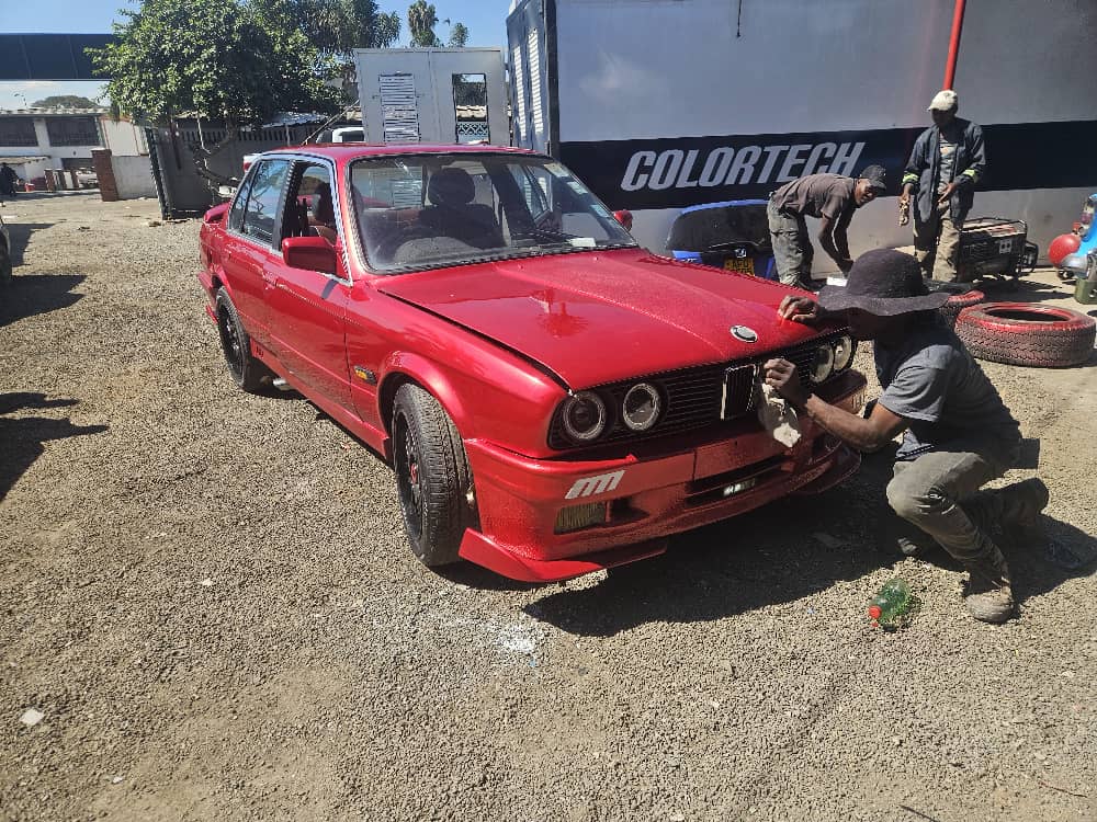 ColorTech Workshop - Professional team working on red BMW showing our expert panel beating and automotive repair services